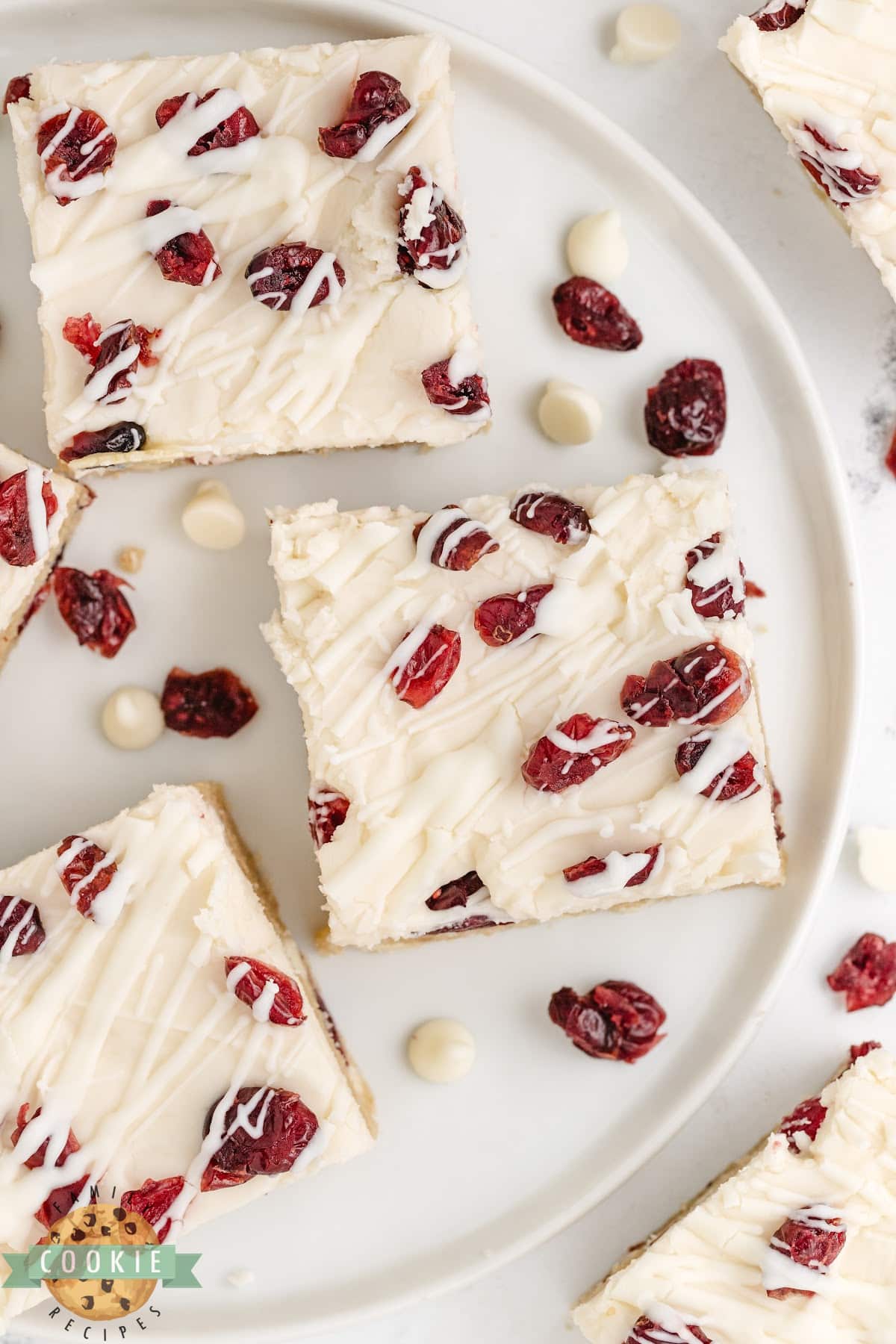 Cookie bars topped with cream cheese frosting, Craisins, and white chocolate drizzle. 