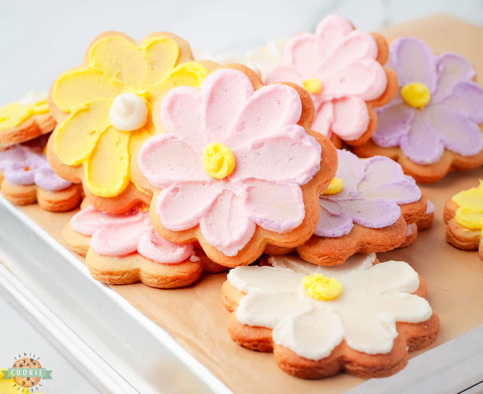 pile of flower cookies with buttercream daisies on them