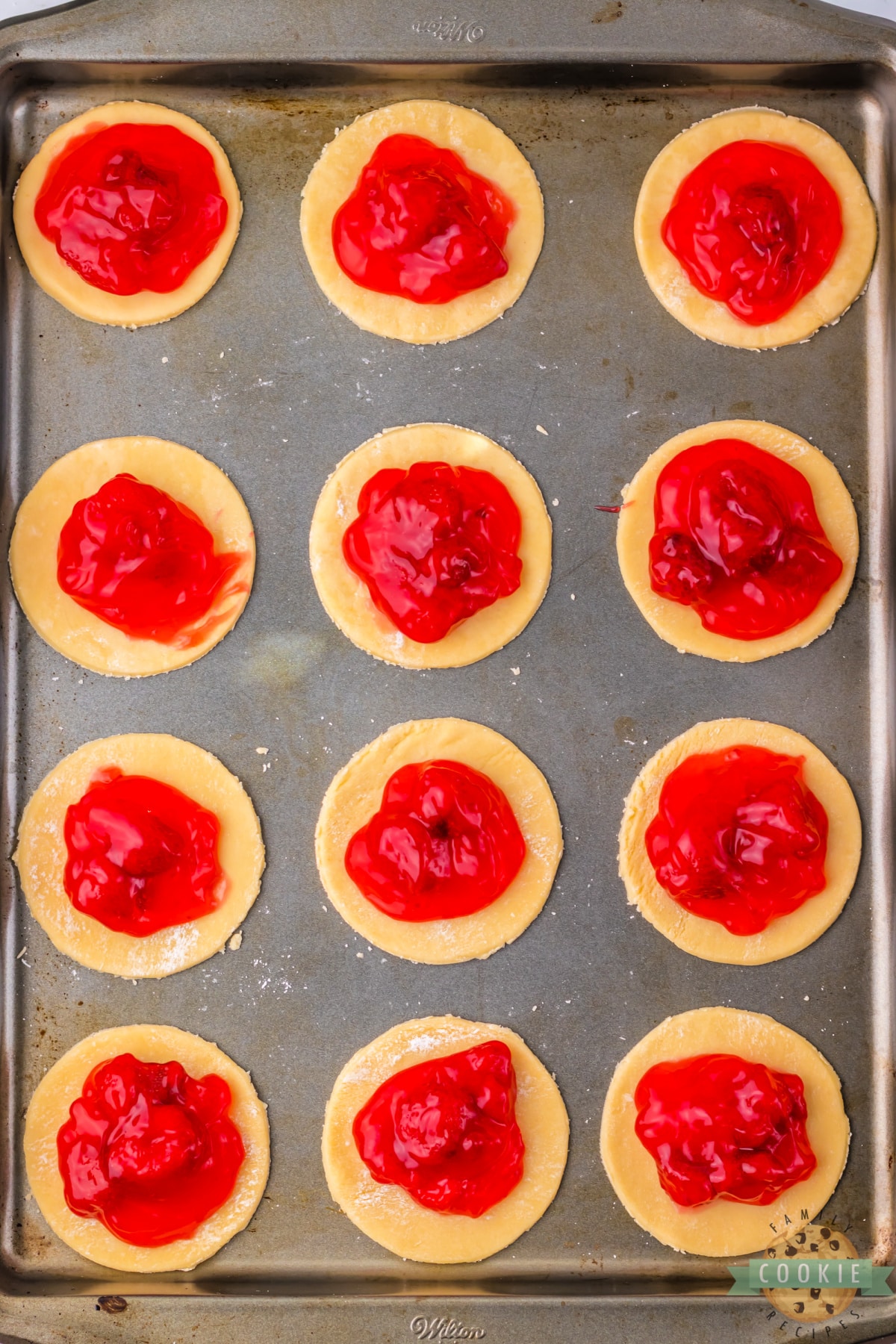 Add strawberry pie filling to the pie crust circles. 