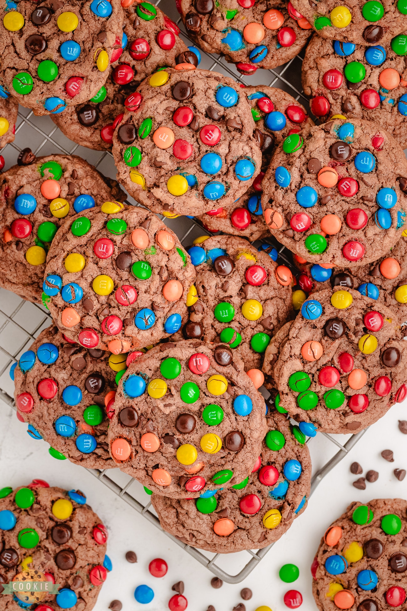 chocolate pudding cookies topped with M&Ms on a cooling rack