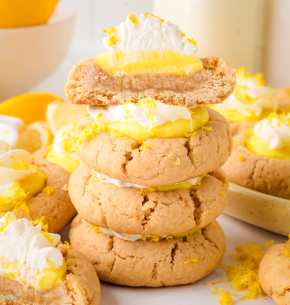 lemon pie cookies with one cut in half showing layers of lemon pudding and lemon cream