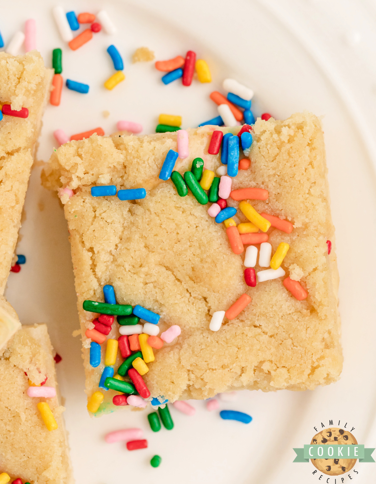 Sugar cookie bars with a cheesecake filling and sprinkles.