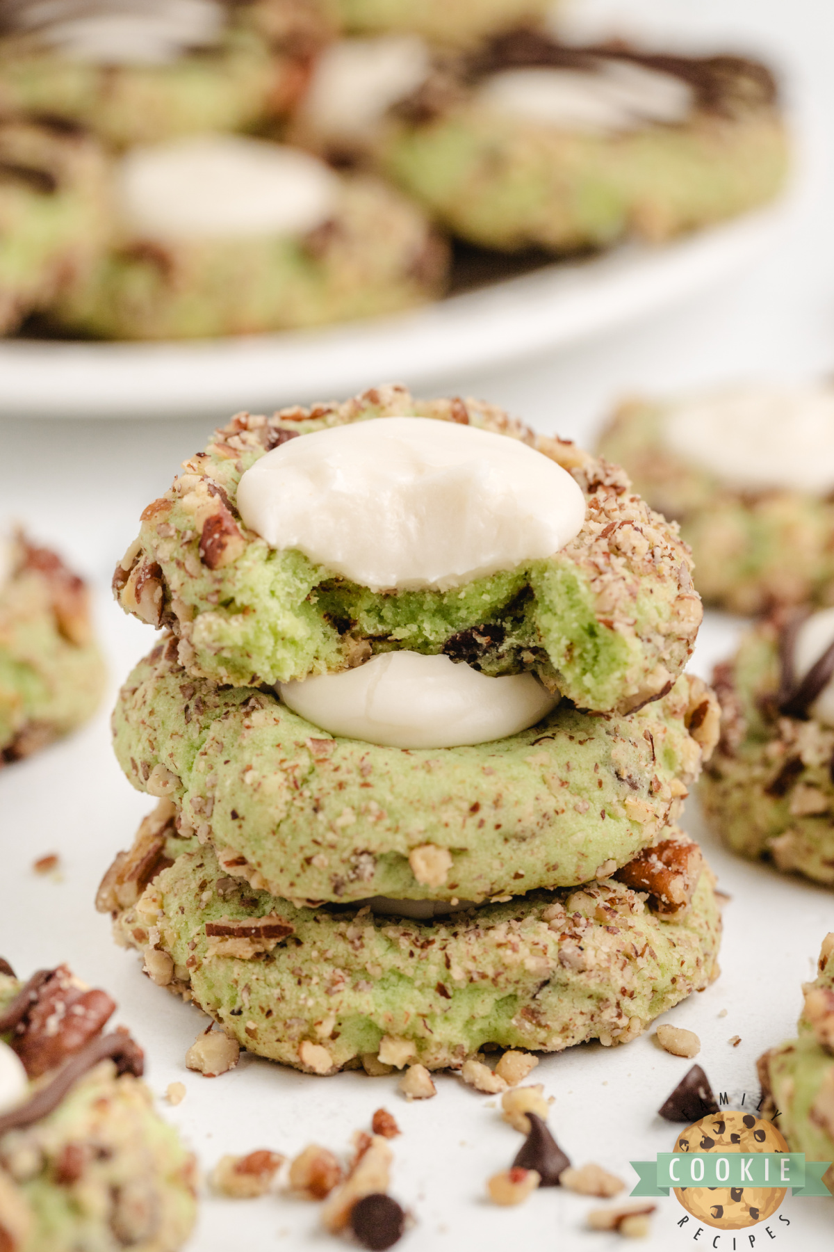 Stack of pistachio thumbprint cookies made with buttercream filling.