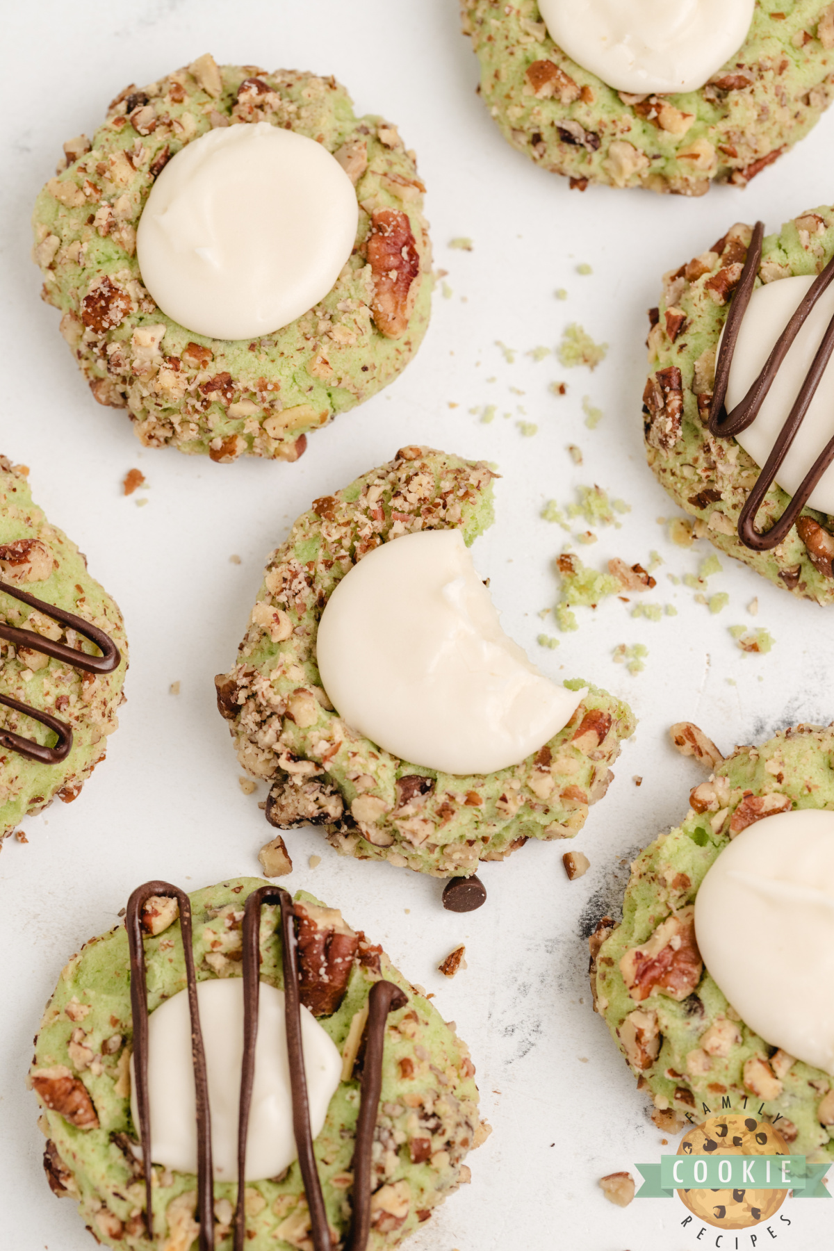 Soft pistachio thumbprint cookies with chocolate chips, pecan coating, and vanilla filling—easy to make and absolutely delicious!