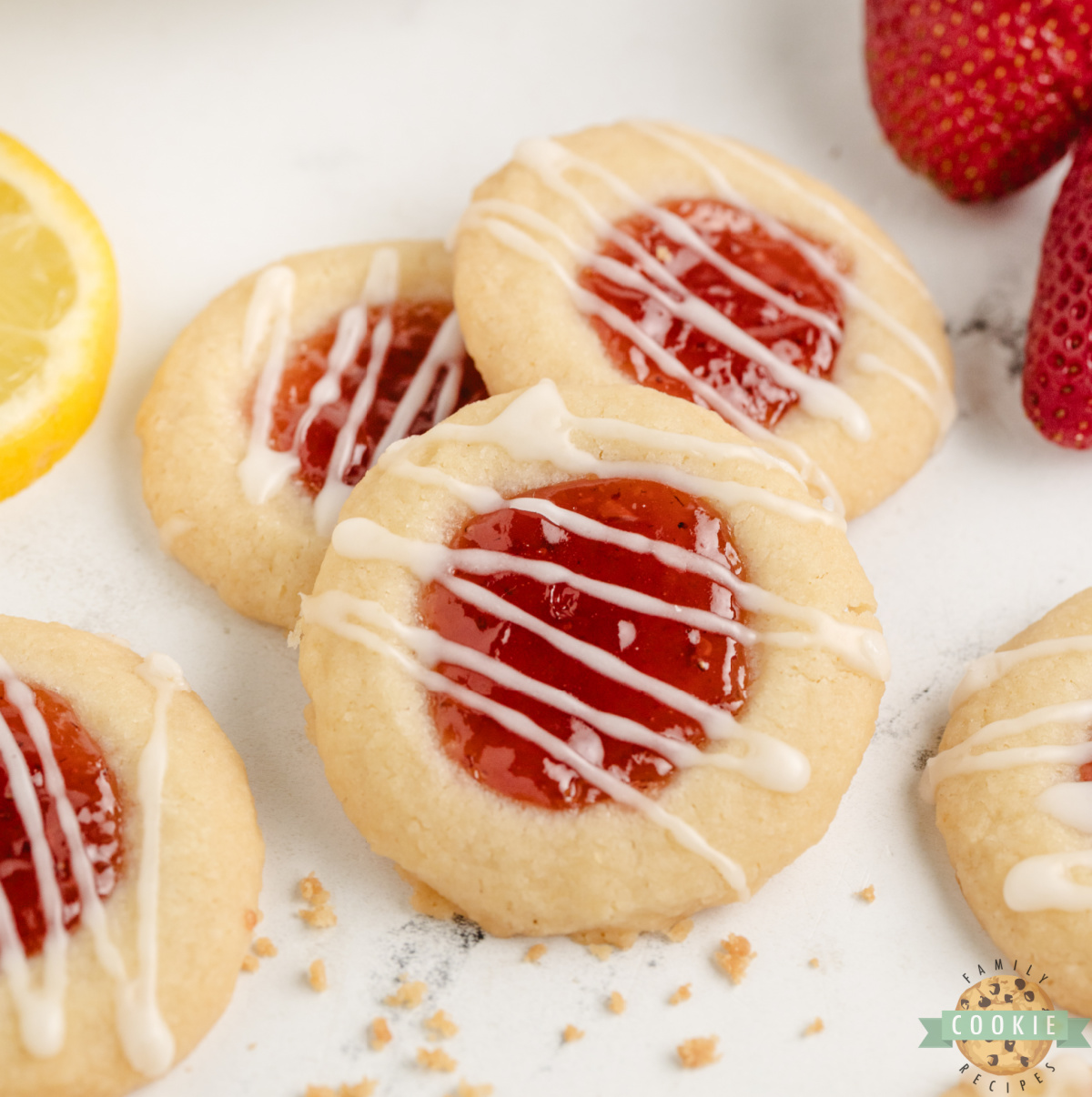 Strawberry Lemon Thumbprint Cookies are buttery, citrusy, and sweet—filled with jam and topped with a tangy lemon glaze!
