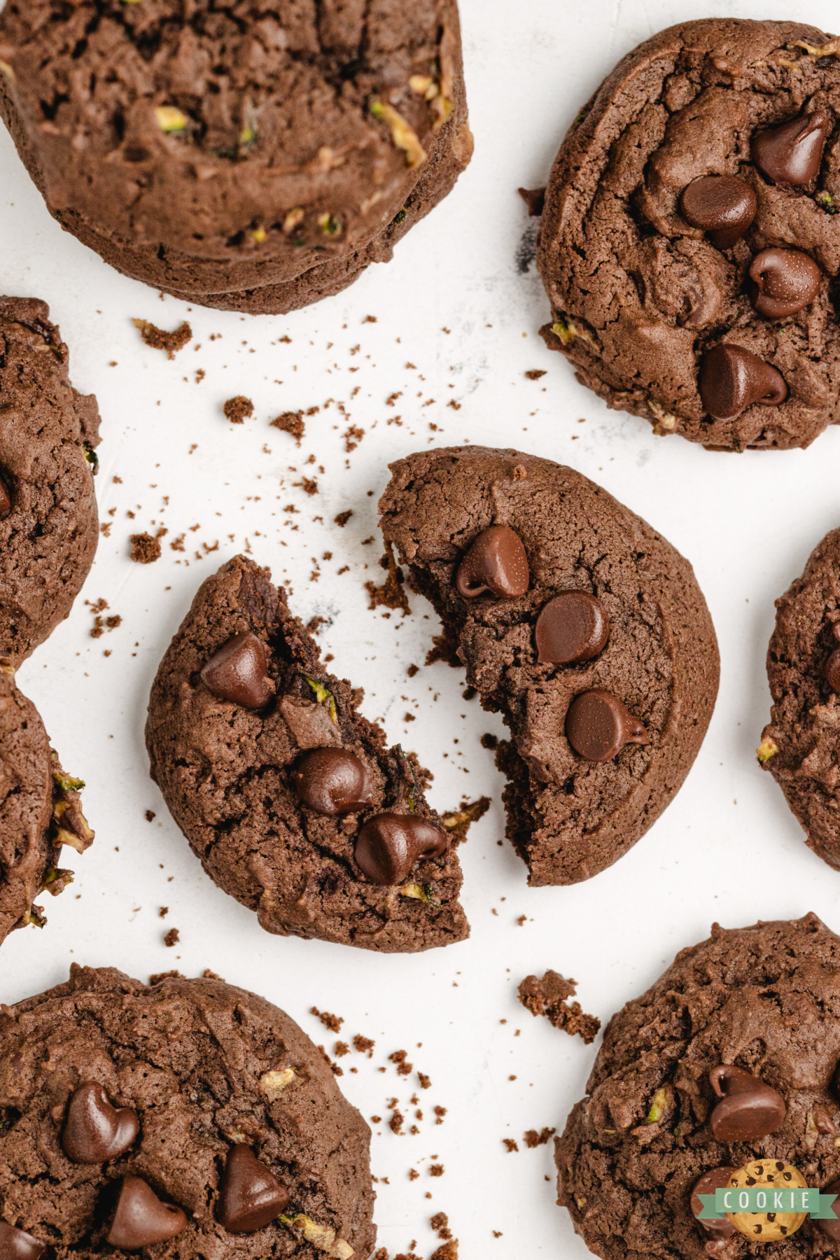 Close-up of a fudgy chocolate zucchini cookie broken in half, showing the rich, moist center.
