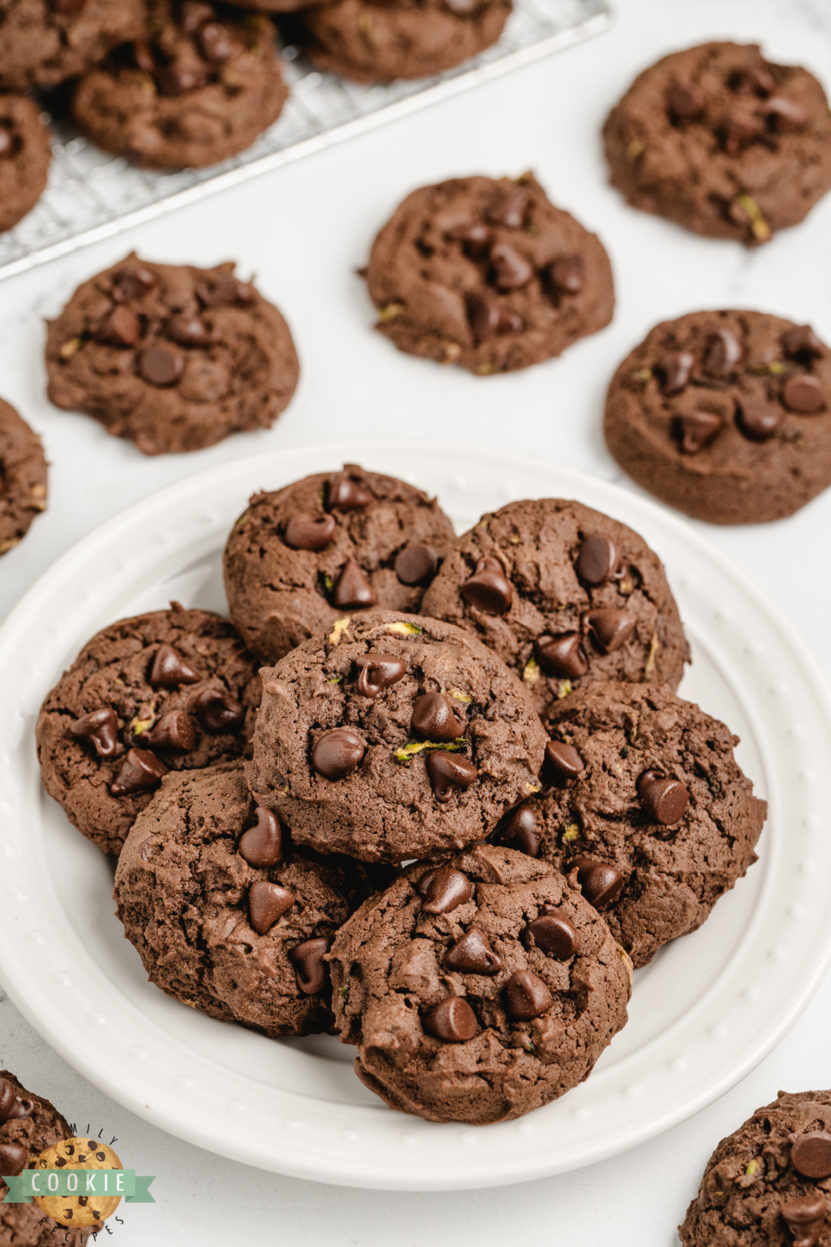 Pile of chocolate zucchini cookies on a white plate.