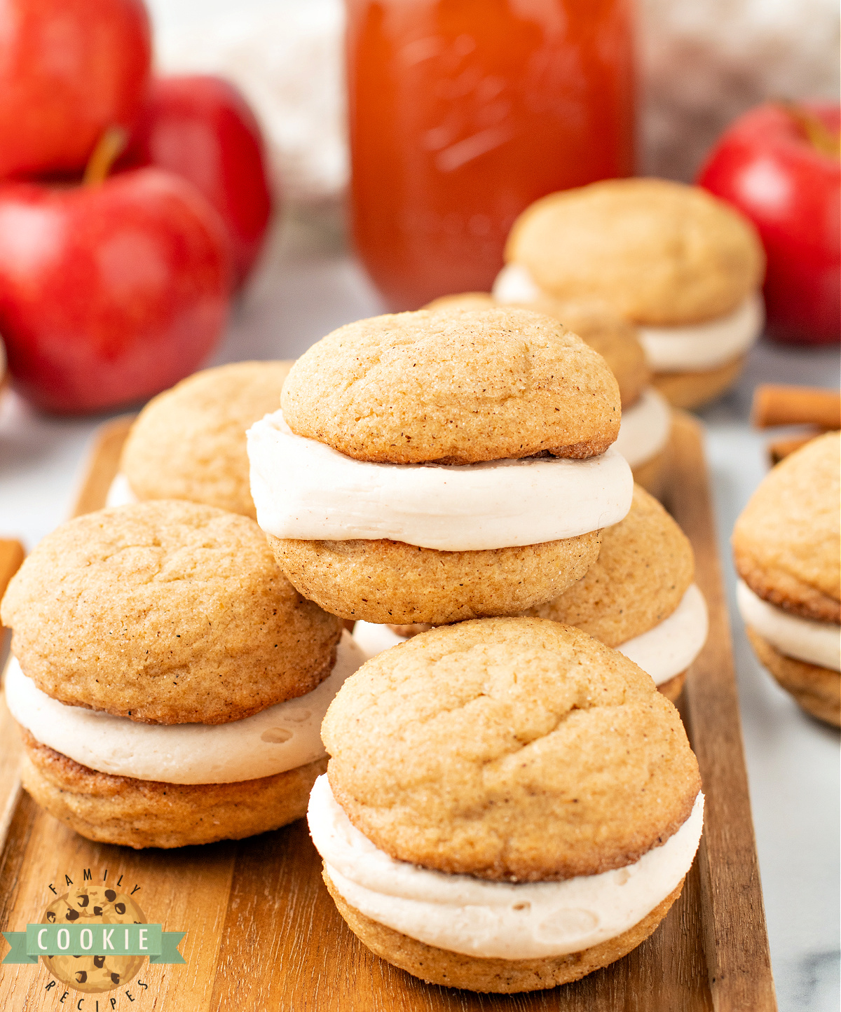 Stack of soft and chewy apple cider snickerdoodle cream pies showing the frosting layer inside.