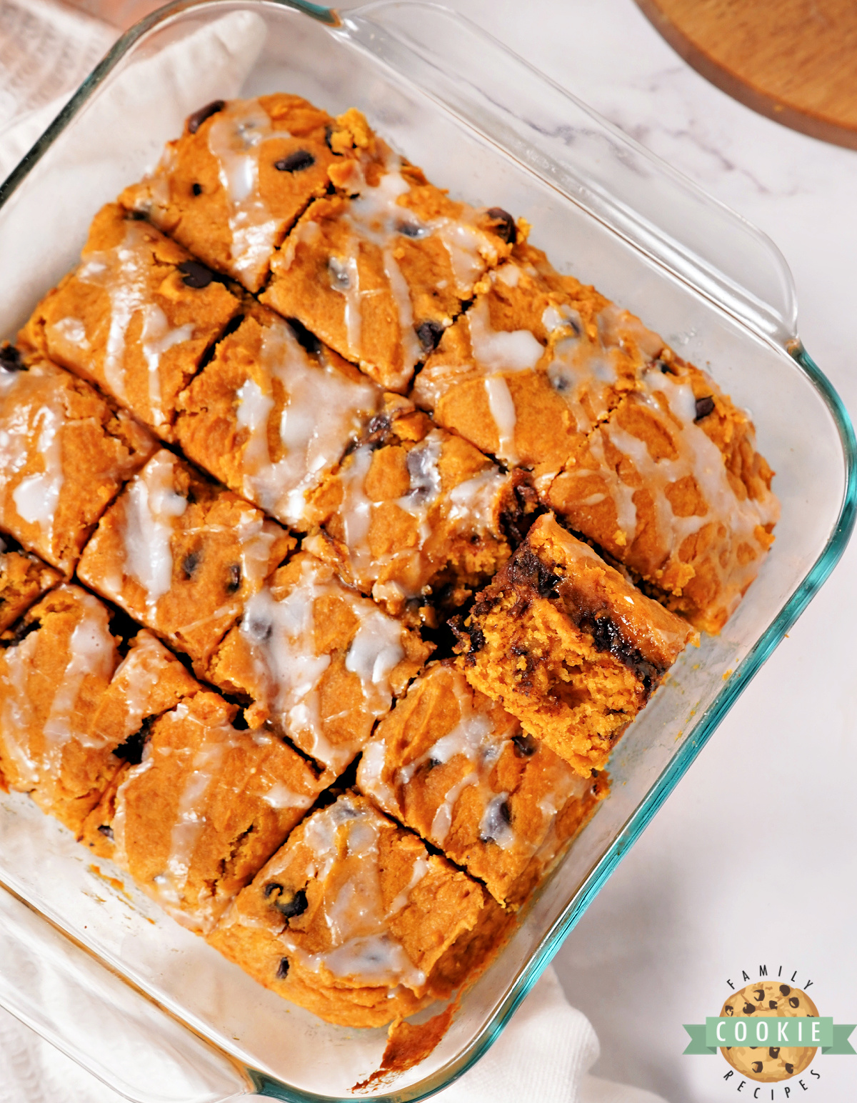 Easy pumpkin dessert bars cut into squares with glaze drizzle.