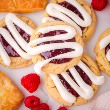 raspberry danish cookies with thick lines of cream cheese frosting