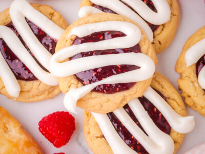 raspberry danish cookies with thick lines of cream cheese frosting
