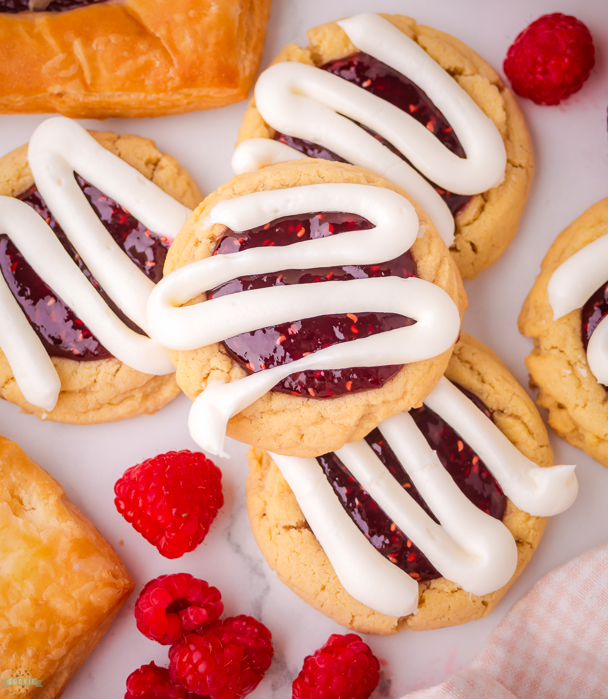 raspberry danish cookies with thick lines of cream cheese frosting