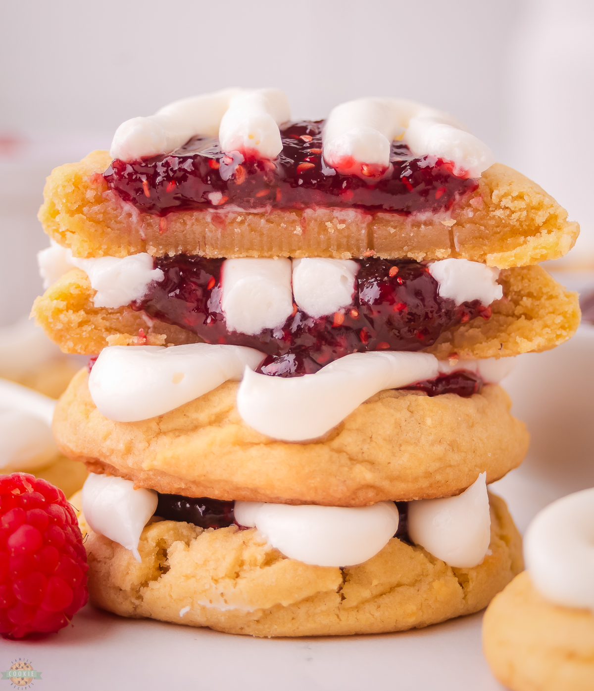 stack of raspberry danish cookies with one cut in half so you can see the jam