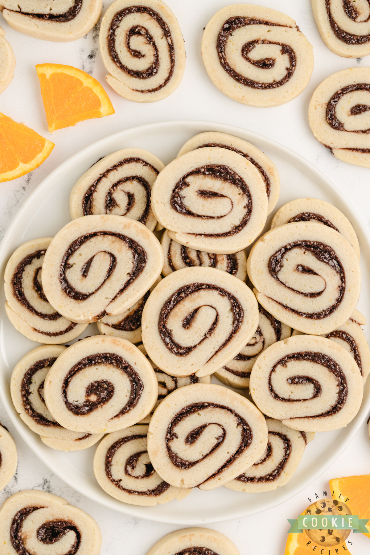 Overhead shot of cookie plate filled with orange-zested pinwheel cookies.