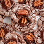 tray of chocolate crinkle cookies topped with fudge and a pecan half