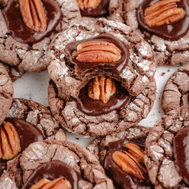 tray of chocolate crinkle cookies topped with fudge and a pecan half