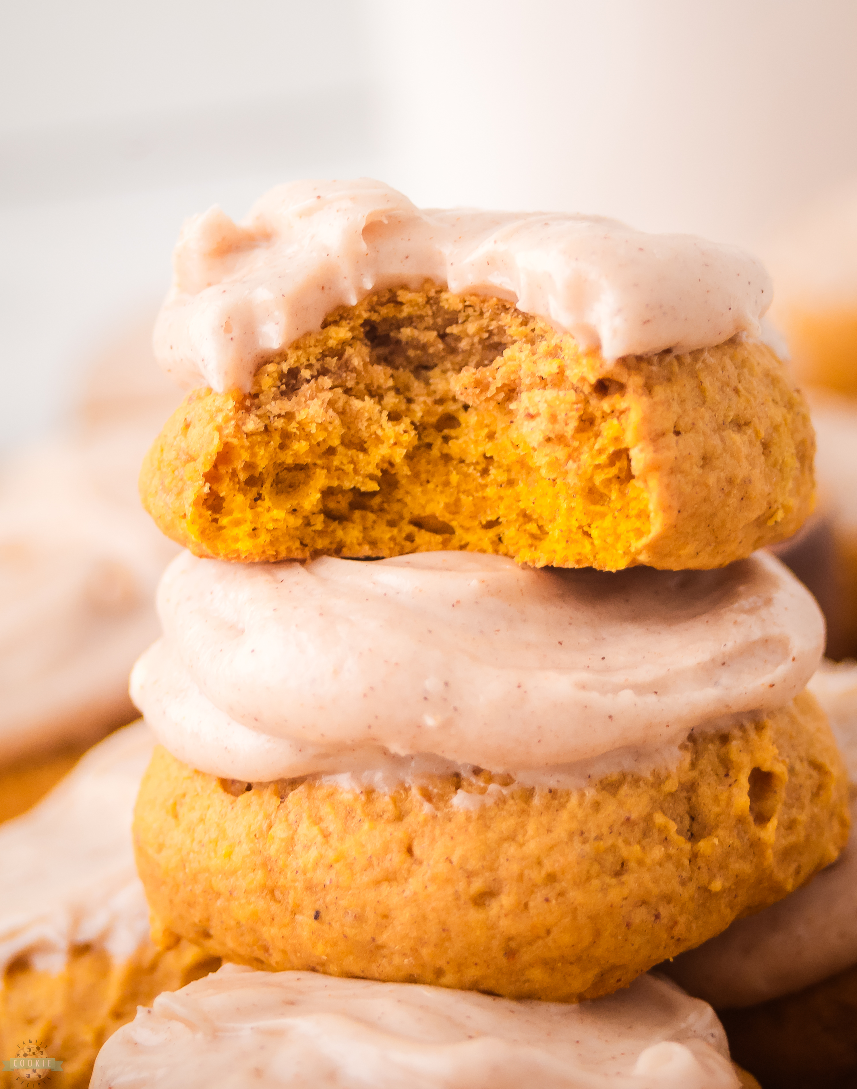 bite taken out of a frosted pumpkin cookie