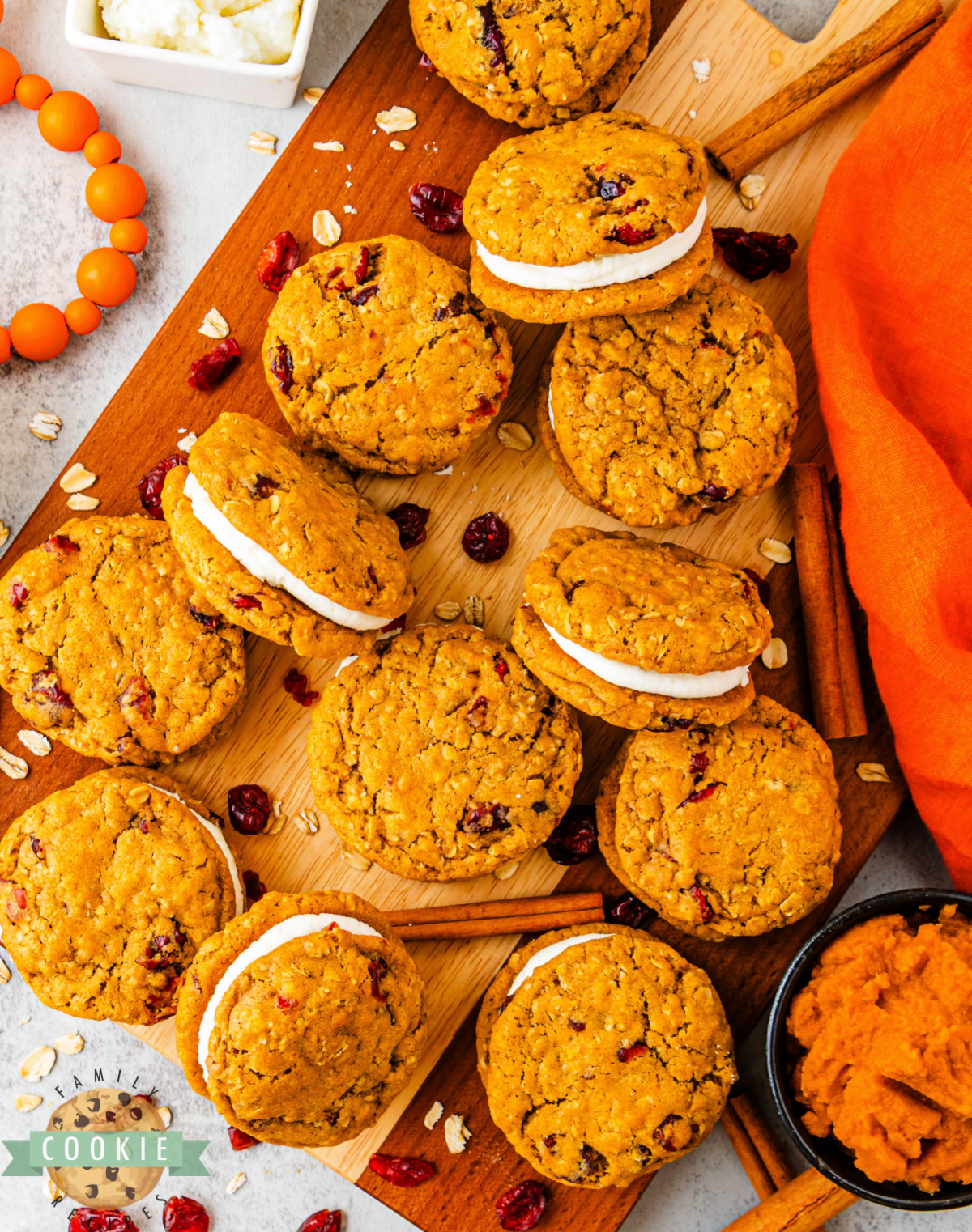 Pumpkin oatmeal sandwich cookies showing soft centers and creamy frosting between layers.