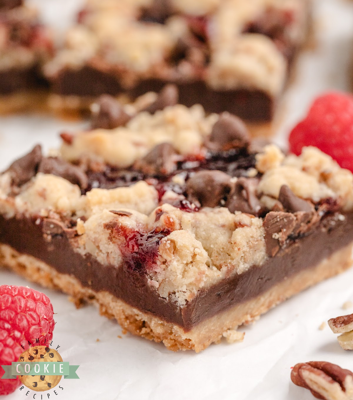 Close-up of chocolate raspberry shortbread bars with jam and chocolate chips.