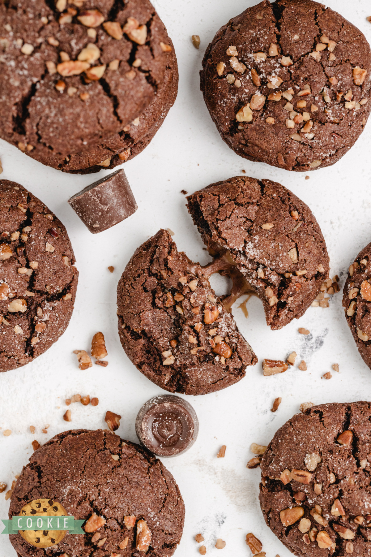 Close-up of chocolate caramel pecan cookies showing cracked tops and melted caramel centers.