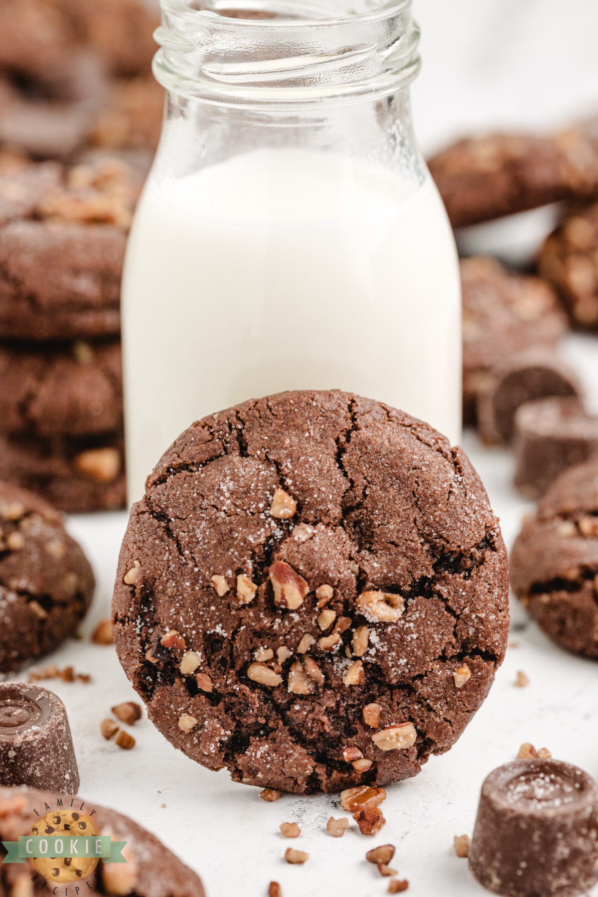 Close up of a Chocolate Caramel Pecan Cookie with a glass of milk. 