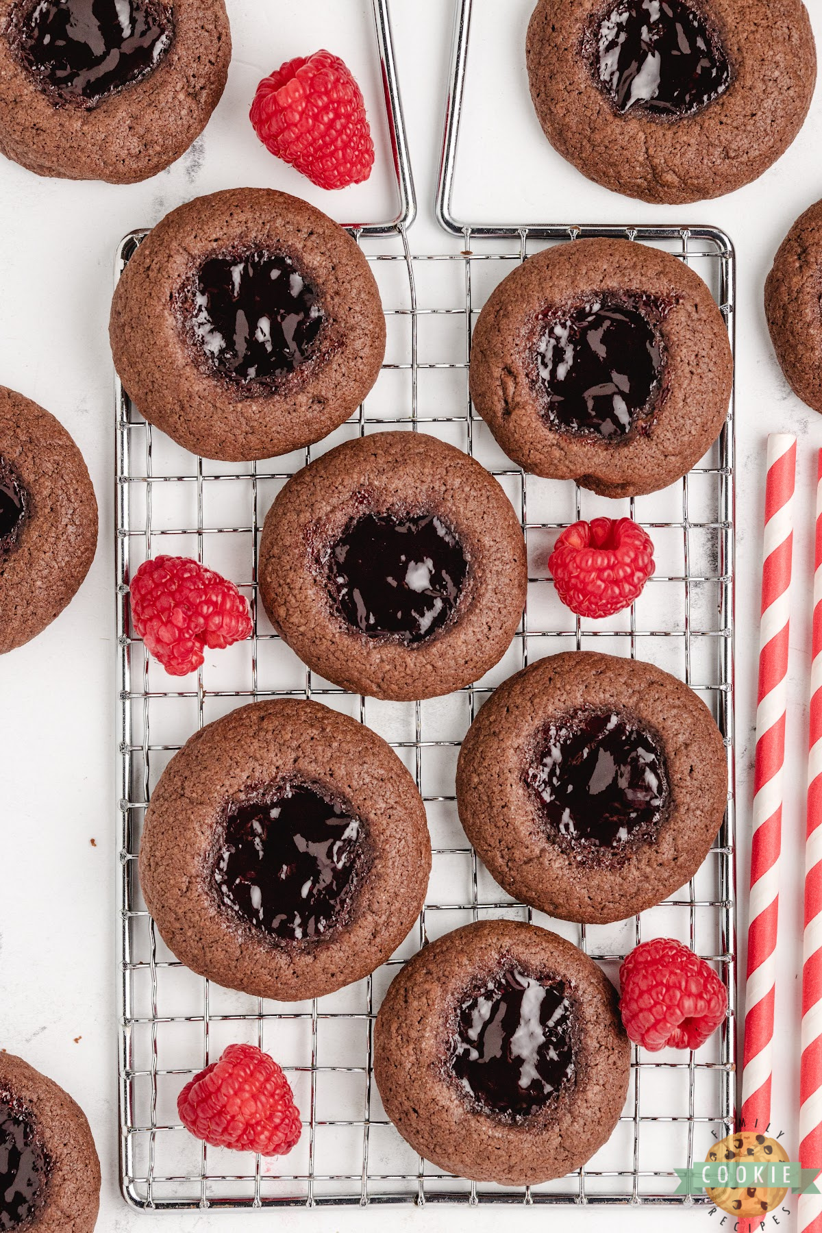 Raspberry chocolate thumbprint cookies cooling on a baking rack.