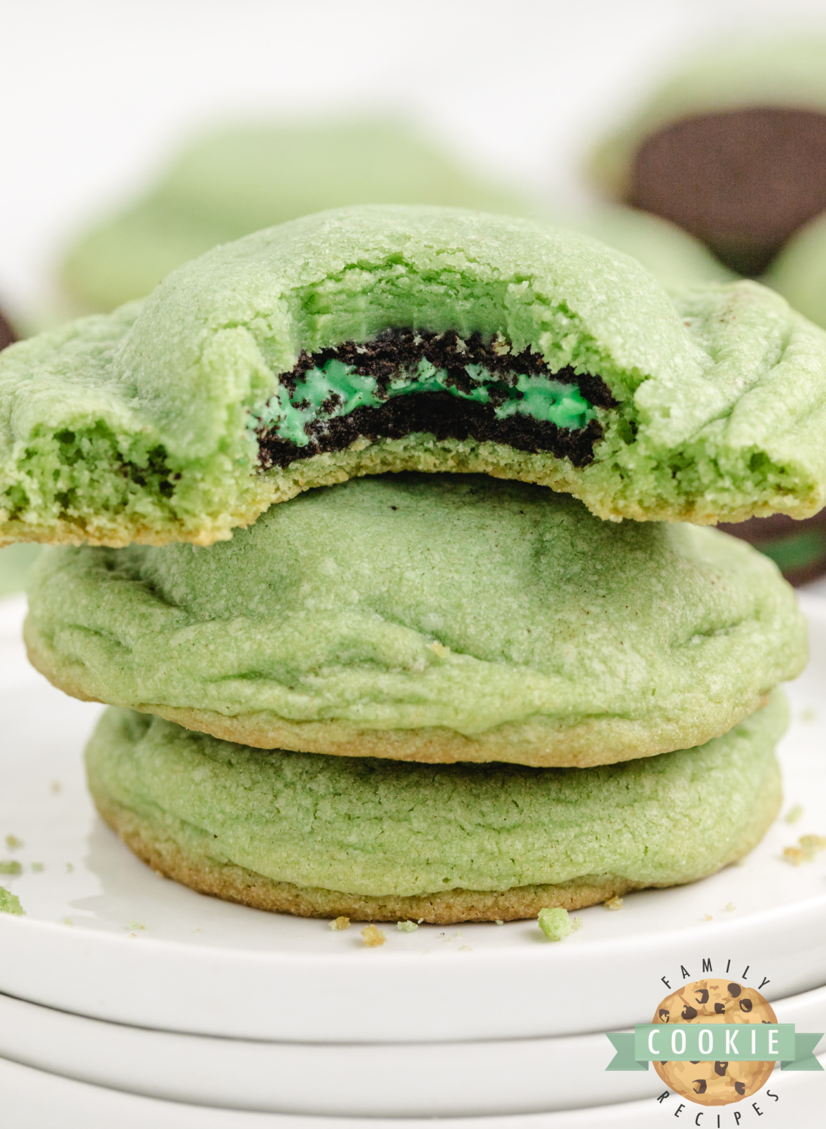 Mint Oreo stuffed cookies stacked on a plate showing the Oreo center.
