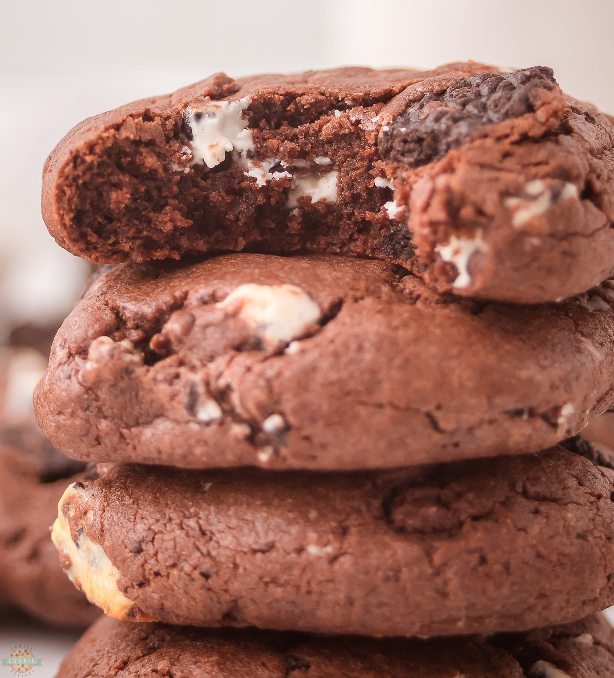 stack of chocolate cookies and cream cookies, one with a bite taken out