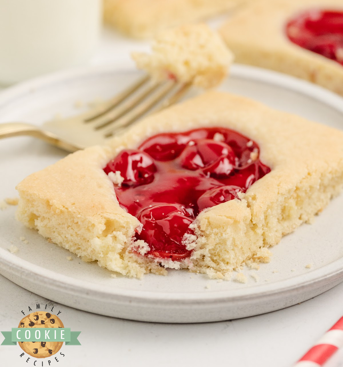 Close-up of a cherry pie cookie bar showing the soft buttery base and sweet cherry pie filling on top.