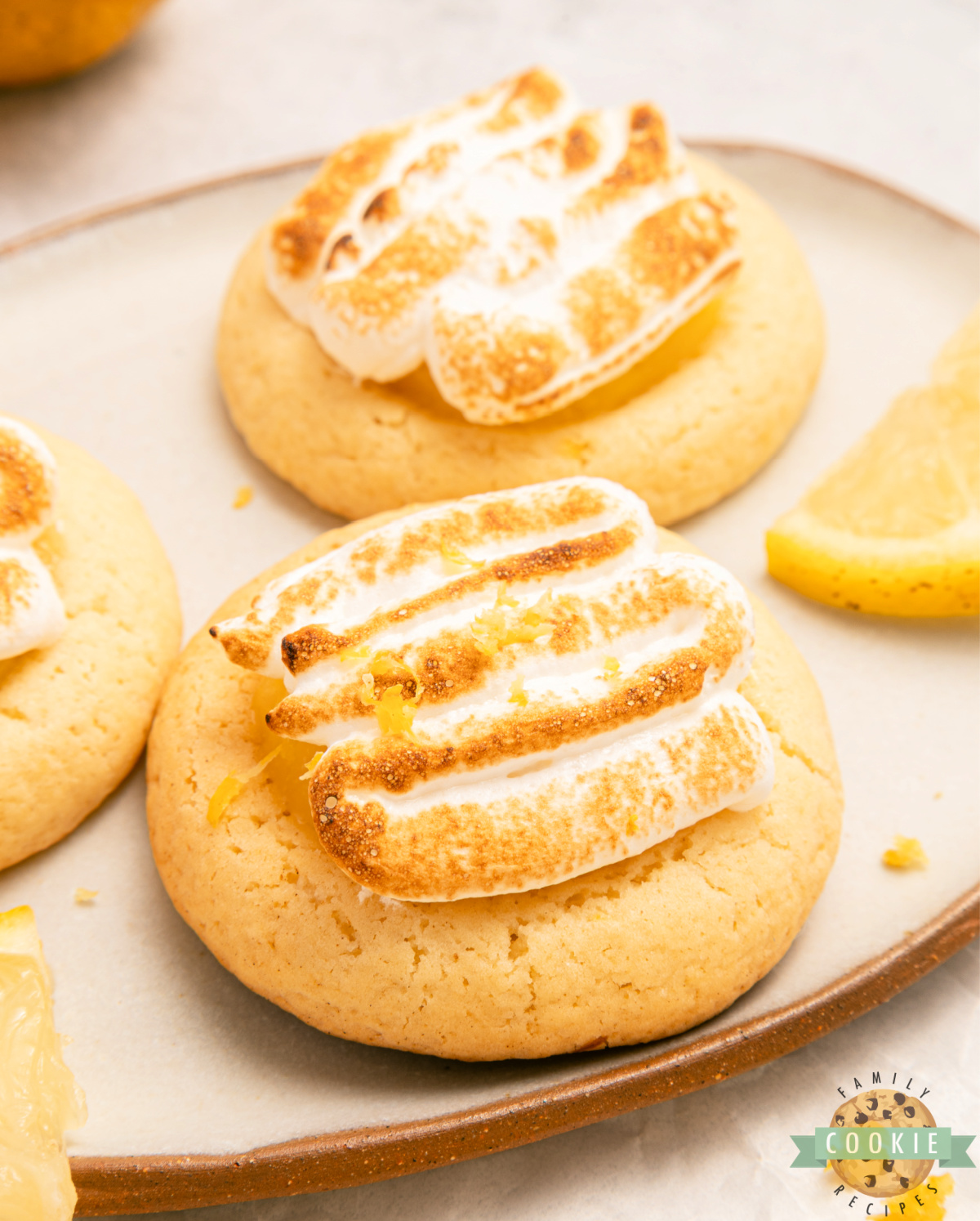 Lemon meringue pie cookies topped with toasted meringue on a platter.