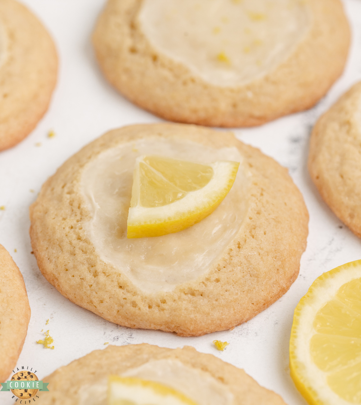 Close-up of a lemon cheesecake cookie showing the creamy white cheesecake topping against the golden lemon dough