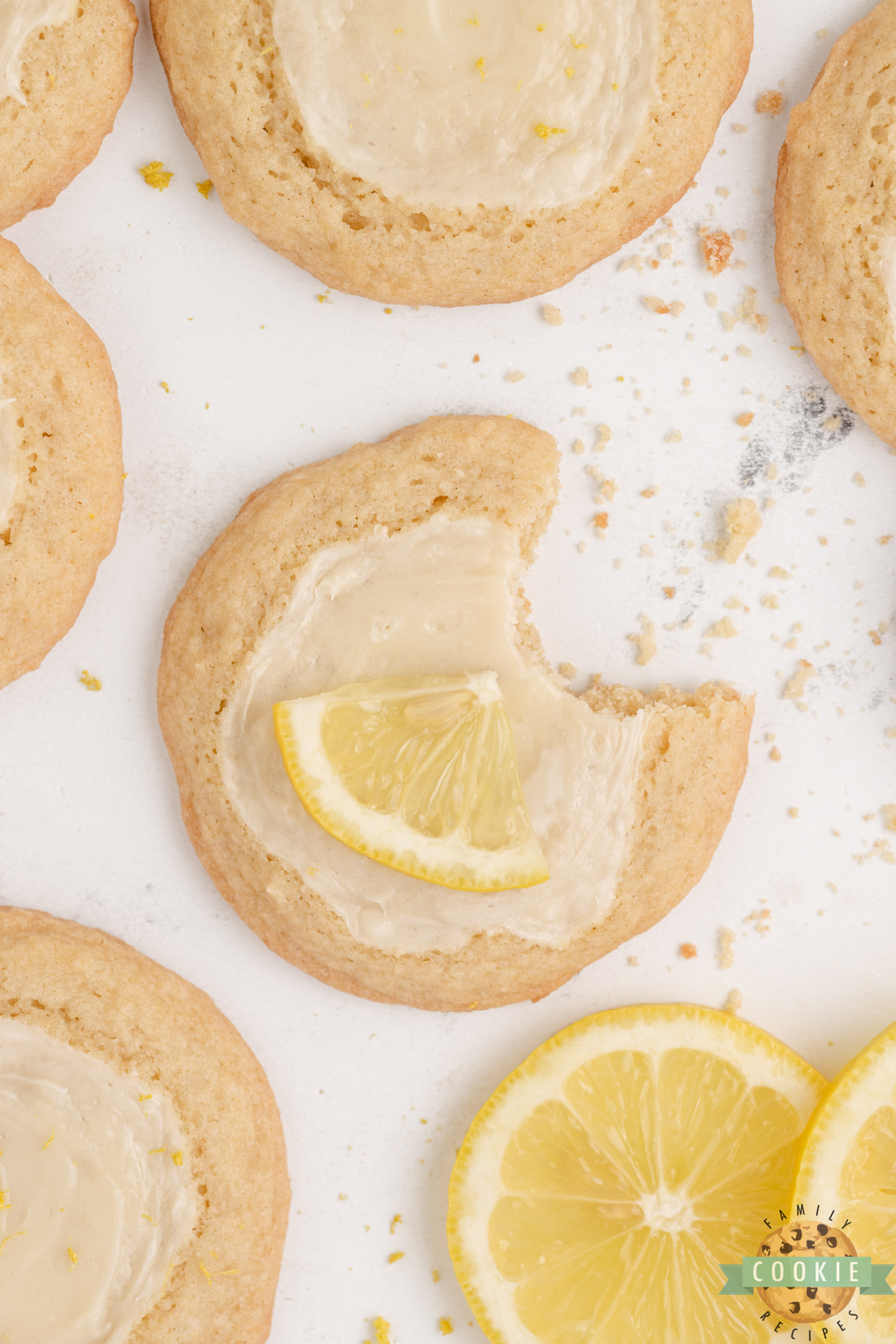 Close-up of a lemon cheesecake cookie showing the creamy white cheesecake topping against the golden lemon dough.