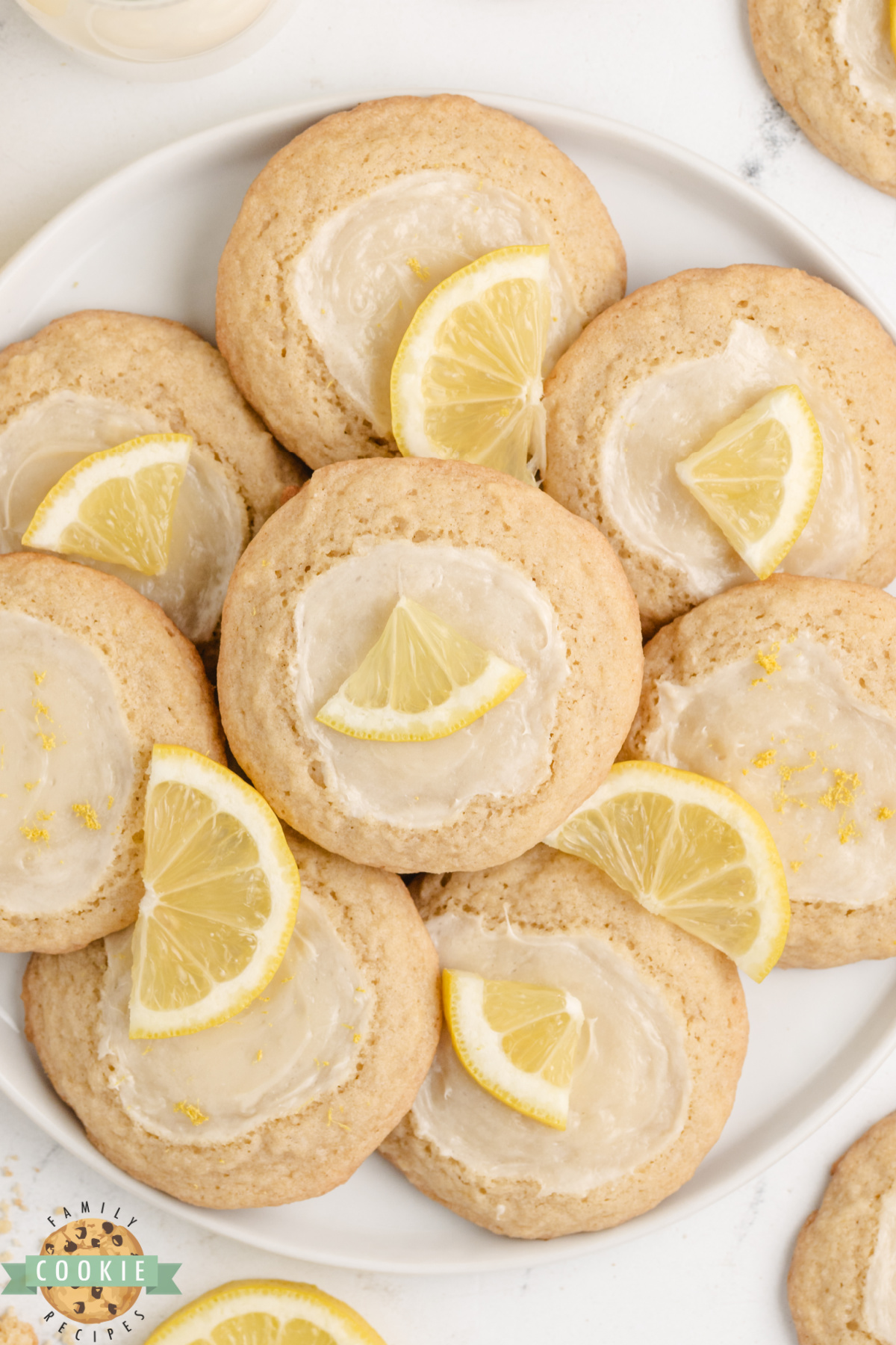 A plate of lemon cheesecake cookies showing the cream cheese topping on golden lemon cookies.